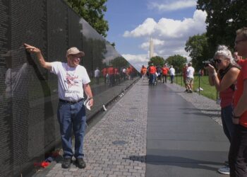 Wilinski poses by a name on the Vietnam Veterans Memorial.