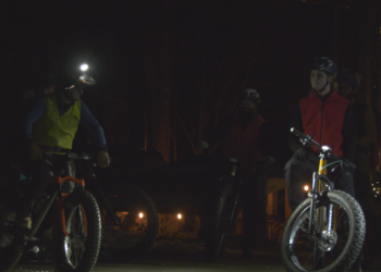 Snow bikers preparing for a night ride on the NTN.