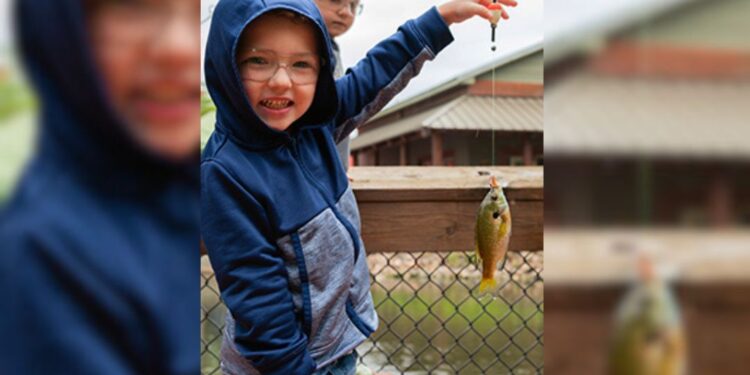 (Courtesy: Michigan Department of Natural Resources) A young boy holds up a bluegill he caught at the Michigan Department of Natural Resources Pocket Park in Escanaba