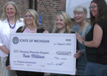 Representative Jenn Hill presents a check to Munising Memorial Hospital.