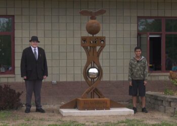 Student designers James Johnsen and Izayah Harris pose with the sculpture
