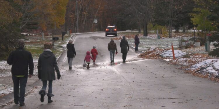 Marquette Trick-or-Treaters cross a street, 2024